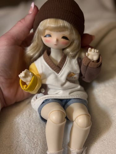 Customer's cute TinyFox doll held in hand, dressed in a casual outfit with a brown beanie.