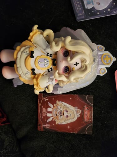 Reviewer's Ninita Witch Revelation Series figure with blonde hair and a yellow dress, shown with its character card.