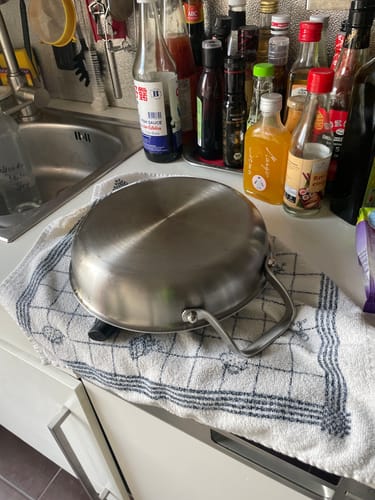 Die Titanpfanne eines Kunden liegt umgedreht auf einem Küchentuch, um neben der Spüle zu trocknen.