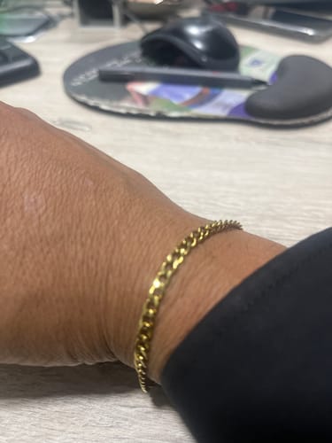 Cliente mostrando la brillante Pulsera Fígaro Oro 5mm en su muñeca.