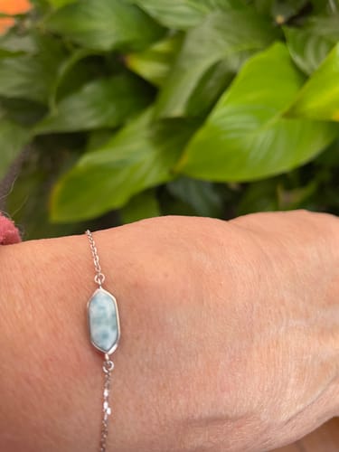 Une cliente porte le fin Bracelet Larimar au poignet, mettant en valeur sa pierre bleu clair.