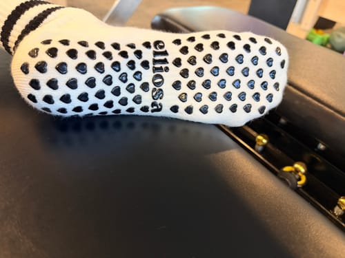 Customer's close-up of the white Dual-Direction Grip Stripes sock, showing the black heart-shaped grips on the sole.