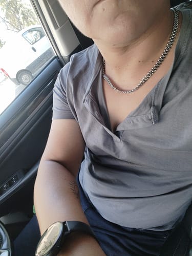 Primer plano de un cliente que lleva puesta la Cadena Cuban Link de 8mm con una camiseta gris.