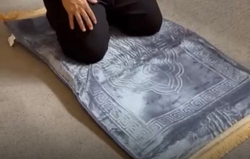 Reviewer kneeling on the plush, grey Medical Prayer Mat.