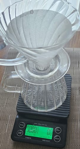 Customer's black Cowpresso Coffee Scale with a glass dripper, tared to zero before brewing.