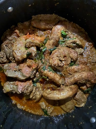 Customer's close-up of cooked Halal Chicken Neck and liver in a rich, savory stew.