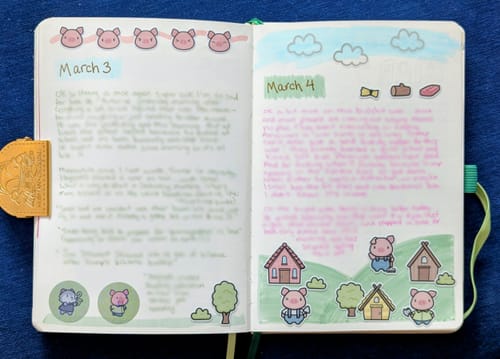 Reviewer's journal open to a cute Three Little Pigs scene created with stickers from the Sticker Subscription.