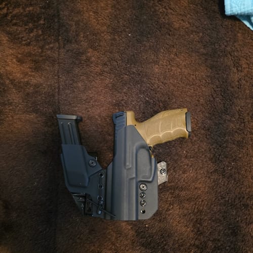 Reviewer's black AXIS ELITE holster holding a handgun with a tan grip and a magazine, viewed from above.