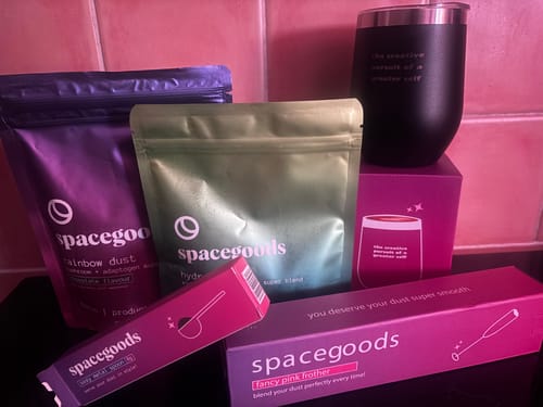 Customer's Rainbow Dust starter kit showing two product pouches, a black tumbler cup, and pink accessories boxes.