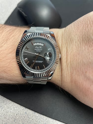 Customer's close-up of the Lucky Fours® Santos watch on their wrist, showing the silver band and black face.