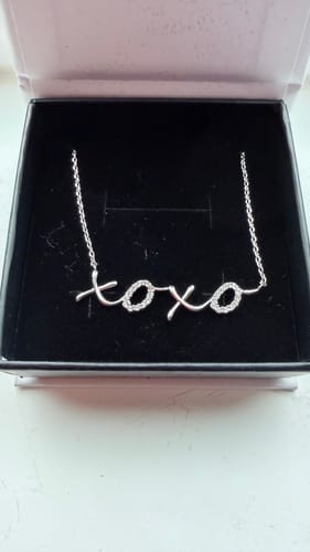 Customer's sparkly Jocelyn XOXO Pendant Necklace resting inside its black gift box.
