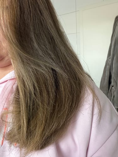 Nahaufnahme des gepflegten, hellbraunen Haars einer Kundin nach der Anwendung der Ylang-Ylang-Glow Haarseife.