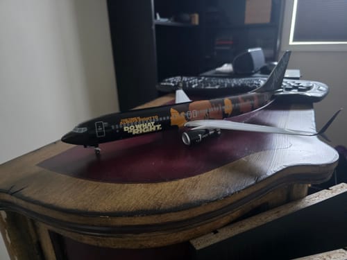 A customer's detailed SKYMARKS ALASKA 737-900 model airplane with its 'Commitment' livery resting on a wooden desk.