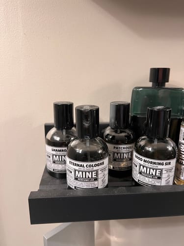 Il flacone di ETERNAL COLOGNE del recensore su una mensola nera tra altri profumi.