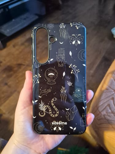Customer holding the Crystal phone case, showing its black, mystical design in their hand.