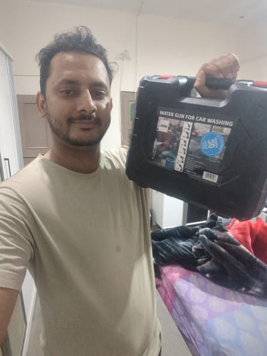 Customer holding the black portable case for their MDHL Rechargeable Pressure Washer.
