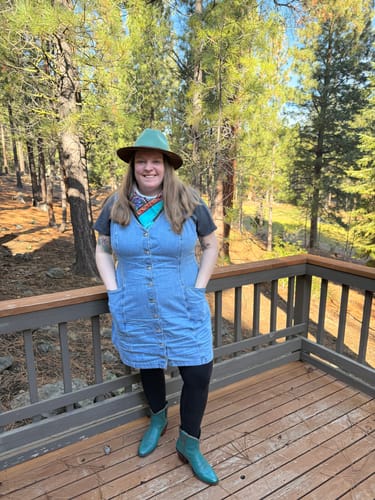 Reviewer wearing the black Ellis Seamless Tights layered under a denim dress while standing on a deck.