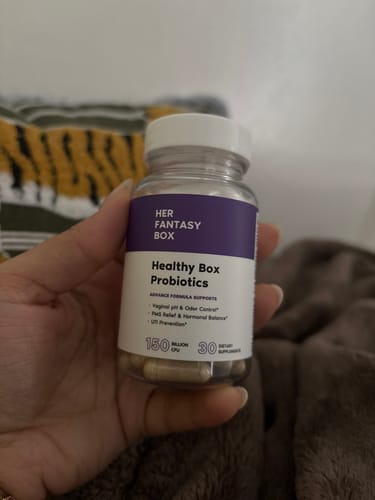 Customer holding a clear bottle of Healthy Box Probiotics with the capsules visible inside.