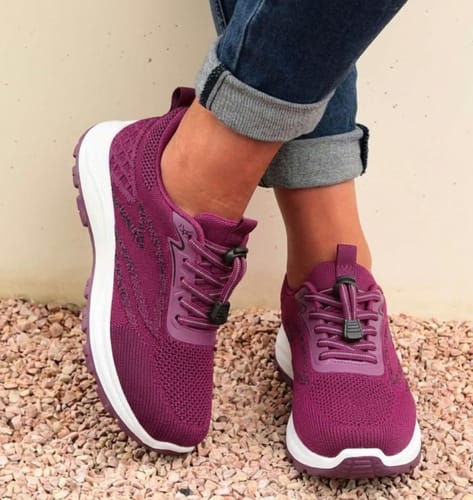 Customer wearing purple Secure Walk 2.0 sneakers with white soles and elastic laces, paired with cuffed jeans.