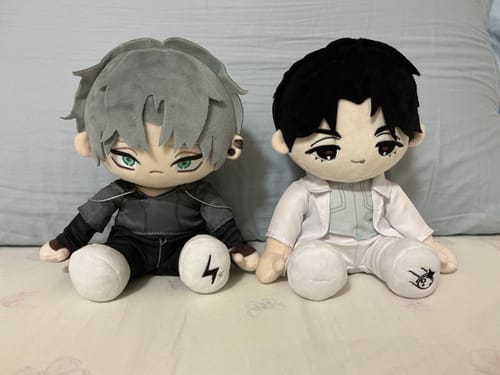 Reviewer's two Alien Stage 20cm Plush Dolls sitting together. One wears a black and grey outfit, the other wears an all-white outfit.