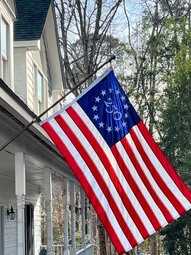 Reviewer's America 250 Collector's Edition Betsy Ross Flag hanging from a flagpole on their home.