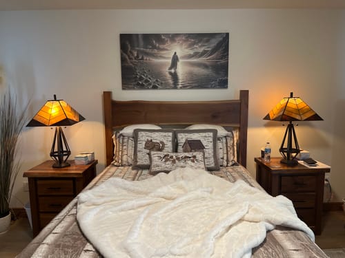 Customer's 'Walking on Water' faith wall art displayed in a bedroom, centered above a wooden bed.