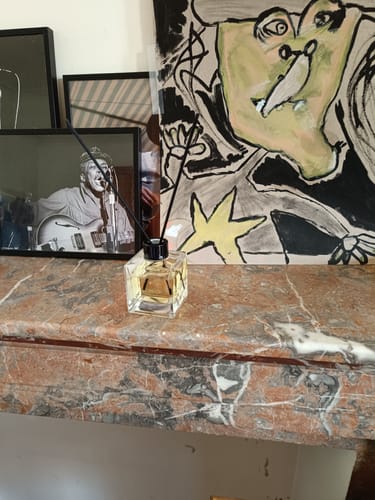 Klant toont de Istanbul Geurstokjes op een elegante marmeren schouw in huis.