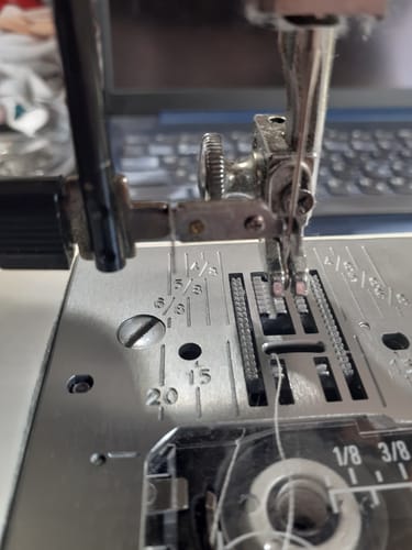 Close-up of the customer's Elna Needle Threader installed and aligned with the needle on a sewing machine.