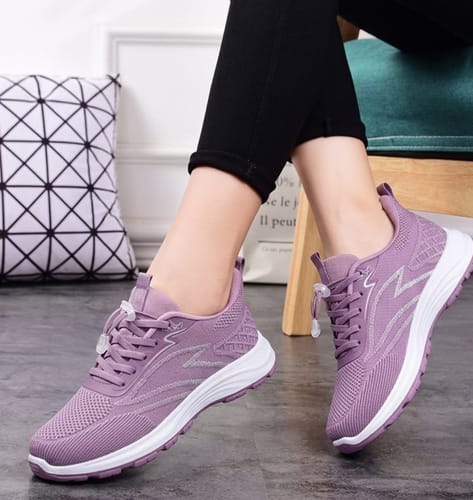 A customer models the purple Secure Walk 2.0 shoes with black leggings, showing the mesh upper and white soles.