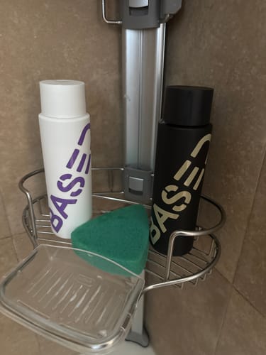 Customer's Shower Duo shampoo and conditioner bottles sitting in a metal shower caddy.