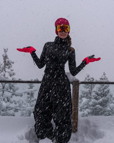 Reviewer standing in the snow wearing the baggy Retro Track Snow Pants with visible reflective piping.