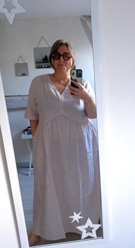 Une cliente se photographie dans un miroir, portant la Robe Edonie rayée en lin/coton terracotta.