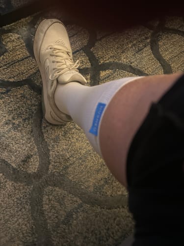 Customer wearing a white Performance Eucalyptus Compression Sock on their lower leg.