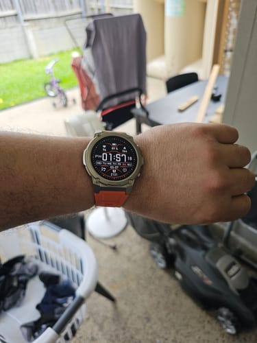 A person's wrist wearing the Gard Pro Ultra 3 watch, which features a digital face and an orange band.