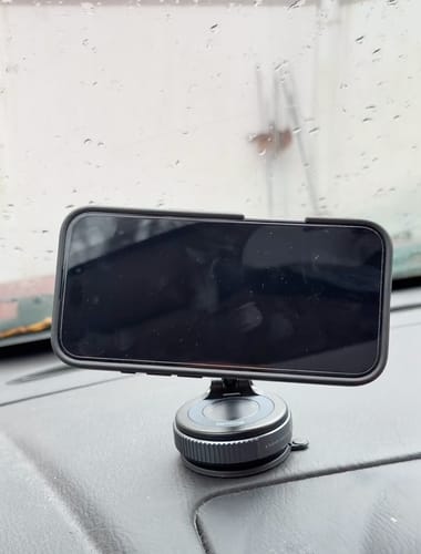 Reviewer's MagPro Magnetic Phone Holder mounted on a car dashboard, holding a smartphone horizontally.