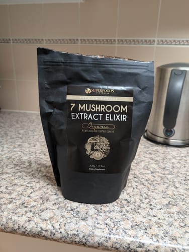 Customer's black pouch of Organic 7 Mushroom Extract Elixir on a kitchen counter.
