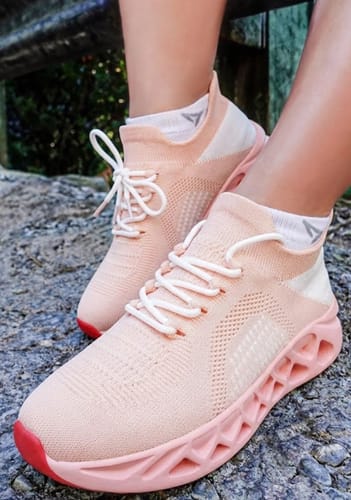 A customer wearing pink Ortho Step shoes, showing the breathable knit upper and unique geometric sole.