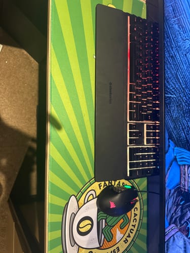 Reviewer's green Cactuar Espresso Coffee desk mat on a desk with a black keyboard and mouse on top.