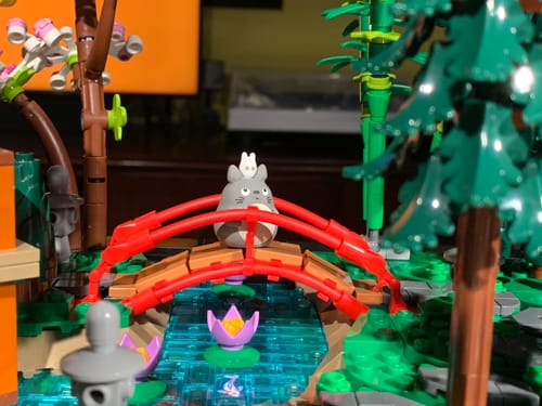 Customer's Mini My Neighbor Totoro Figure sitting on a red bridge within a detailed Lego Japanese garden.