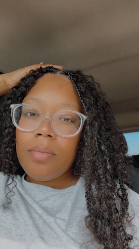 Customer's close-up of her dark Water Curly hair extensions styled with braids.
