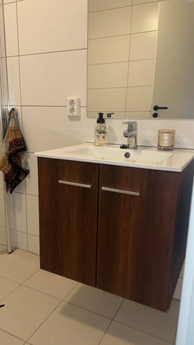 Kunde viser frem en baderomsinnredning fornyet med Varm valnøtt kontaktplast.