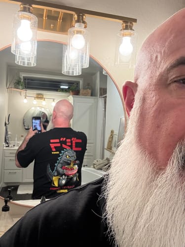 Reviewer takes a mirror selfie to show the back of the black RAMEN MONSTER TEE, which has a monster eating ramen graphic.