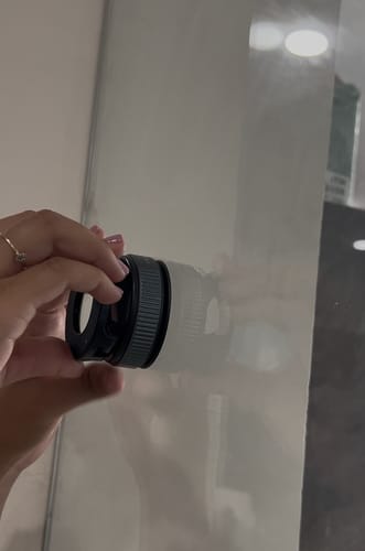 A customer's hand holding the black 360° MagPro Magnetic Phone Holder against a mirror.