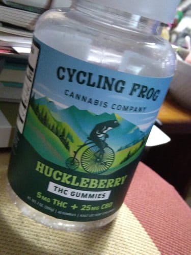 A customer's clear bottle of Huckleberry Gummies, showing the 'Cycling Frog' brand label.