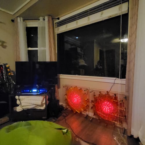 Customer's Qi Coil Aura Scalar System set up on a wood floor in front of a window, with two coils glowing red.