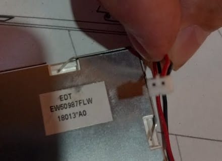 Close-up of a customer's hand holding the new wire connector for the Janome LCD Unit.