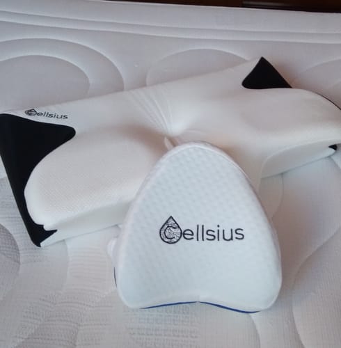 Photo d'un client montrant le coussin cervical Cellsius avec un petit coussin de soutien sur un matelas.