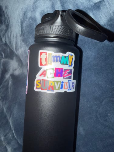 Customer's Tummy Ache Survivor sticker with colorful lettering on a black water bottle.
