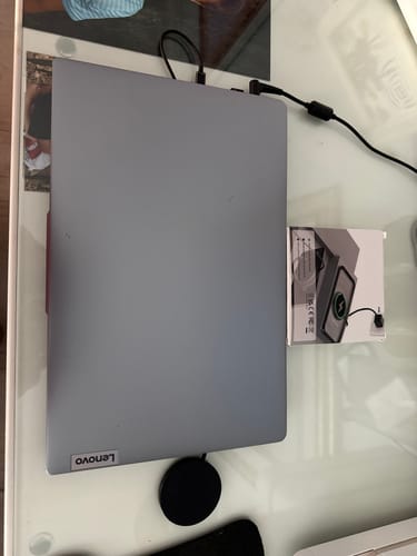 Customer's black SPOTMINDERS Wireless Charger on a desk next to a laptop and its packaging.