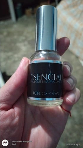 Cliente sosteniendo en su mano el frasco de 30 ml de la fragancia Esencial H506.
